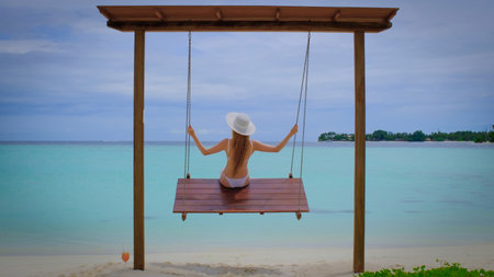 Woman in a bikini is on swings.の写真素材