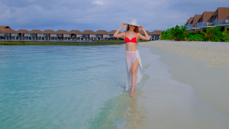 Woman in a bikini is walking. Female is happy on Maldives.の写真素材