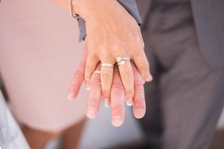 Close up of hands of a newly wed married couple with wedding rings.の写真素材