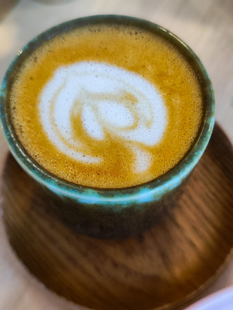 Close up white coffee cup with heart shape latte art foam.の写真素材