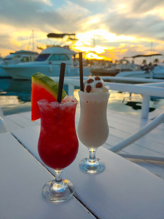 Tropical cocktail decorated with fresh watermelon at the seaside at sunset.の写真素材