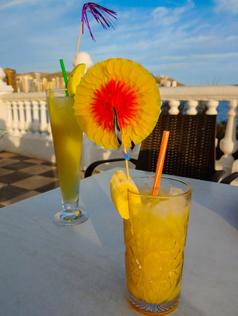 Yellow cocktail with a banana is standing on a table.の写真素材