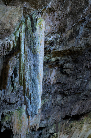 The image showcases a rugged cave interior with stalactites and stalagmites.の写真素材