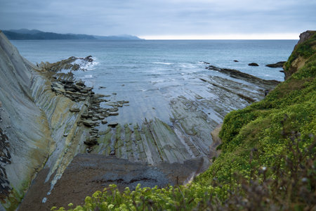 Dramatic coastal scene in the north of Spain, featuring unique rock formations extending into the sea.の写真素材