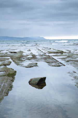 A serene coastal scene from the north of Spain featuring tidal rock.の写真素材