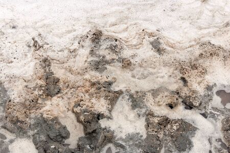 Thick clay is covered with waves of a salt lake.