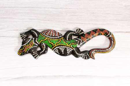 Rear view of a colorful and decorative lizard on a wooden gray background with intentional selective focus and shallow depth of field.の写真素材