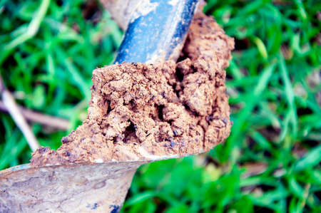 Pieces of earth on the cavity of the motor-drill. Close up.