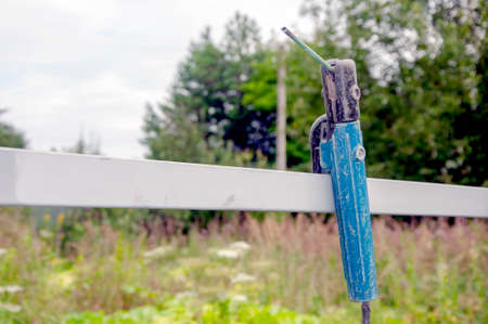 Vintage welding pliers on the fence. Old and rusty weld machine in the garden. Close up macro