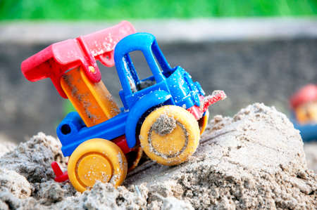 Children s toy car, colorful plastic lorry on sand. Close-up. Selective focus. Copy spaceの写真素材