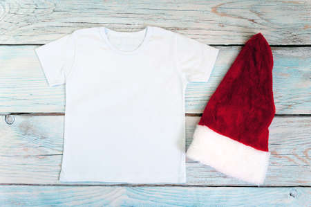 Christmas kid shirt mockup - white tshirt on wooden background. Stock photo.の写真素材