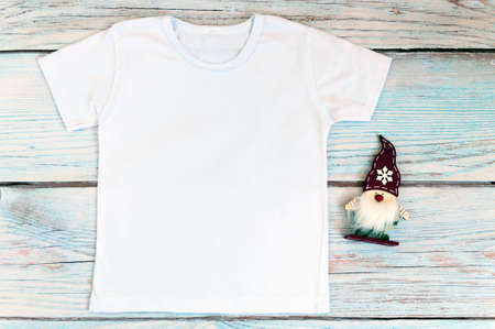 Christmas kid shirt mockup - white tshirt on wooden background. Stock photo.の写真素材