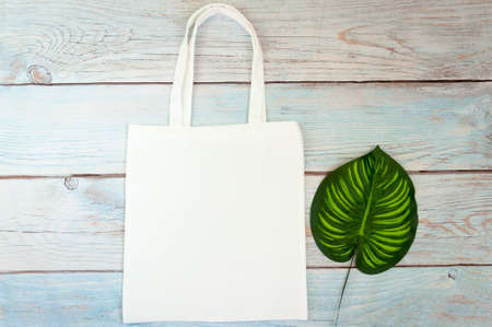 Tote bag canvas fabric cloth shopping sack mockup blank template on wooden background. Stock photo.の写真素材