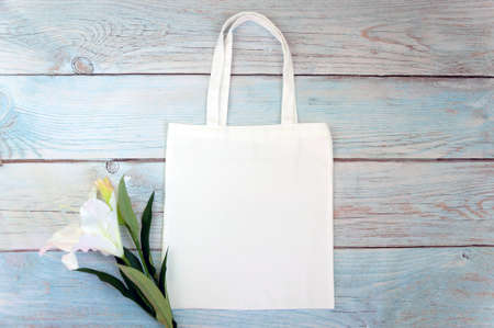 Tote bag canvas fabric cloth shopping sack mockup blank template on wooden background. Stock photo.