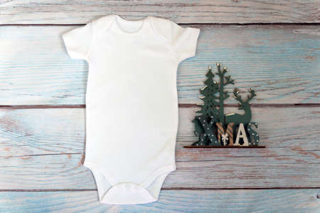 White baby bodysuit mockup on wooden background. Styled stock photography. Mock upの写真素材