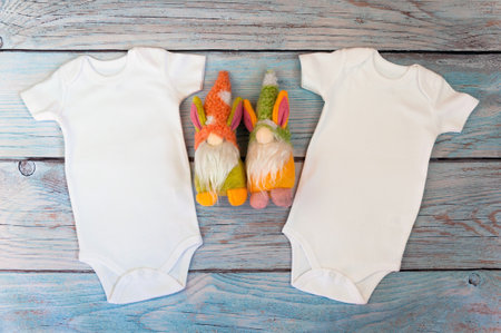 Layout Flat Put on a two white baby bodysuit on a wooden background with gnomes toys. Layout for design and placement of logos, advertising. Styled stock photography, stock photo. flat lay.の写真素材