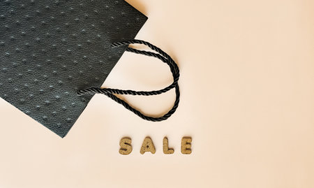 Black bag on a beige background with the inscription Saleの写真素材