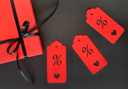 A red box with a black bow on a black background.の写真素材