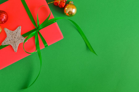 Green Christmas background with space for text, a gift, and Christmas tree decorations. Top view.の写真素材