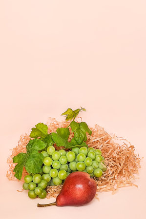 Green grapes and red pear on a beige background, compositionの写真素材