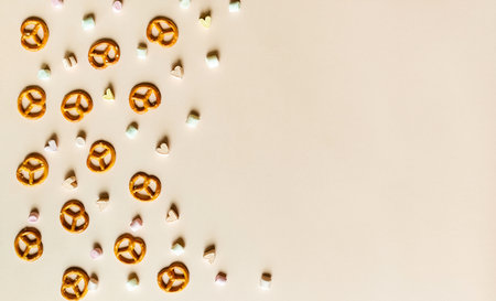 Marshmallows and pretzels on a beige background. Space for text, top view.の写真素材