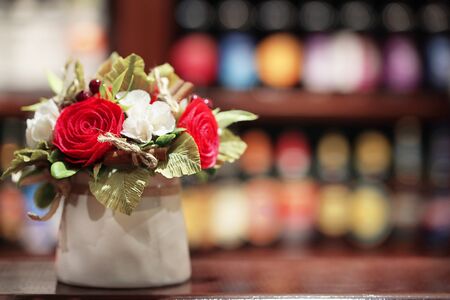 Bouquet of white and red flowers in a light ceramic vase on a wooden tabletop, beer barの写真素材