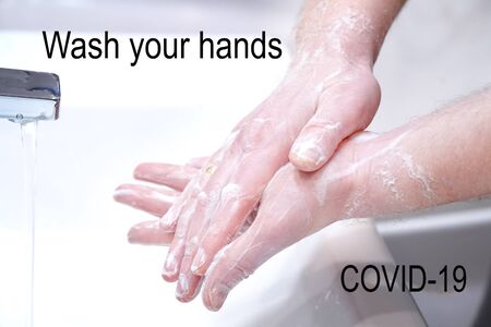 Man wash his hands with soap at home.の写真素材
