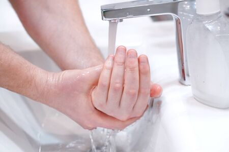 Man wash his hands with soap at home.の写真素材