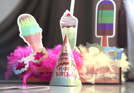 blurred festive setting. Feathers, birthday cap, paper sweets.の写真素材