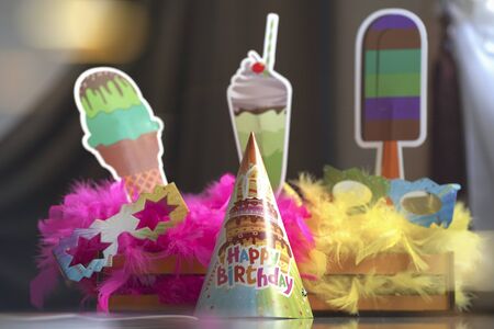 blurred festive setting. Feathers, birthday cap, paper sweets.の写真素材