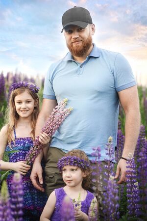 family in a lupin field, father and two dauthersの写真素材