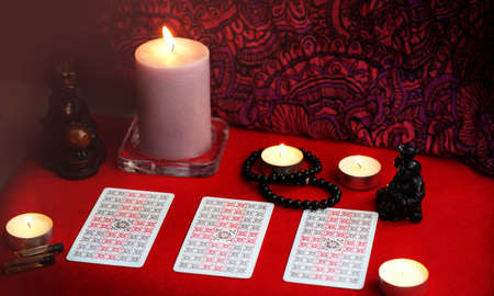 Defocused mystic ritual with tarot cards, and candles. Halloween concept, black magic or fortune telling rite with occult and esoteric symbols.のeditorial素材