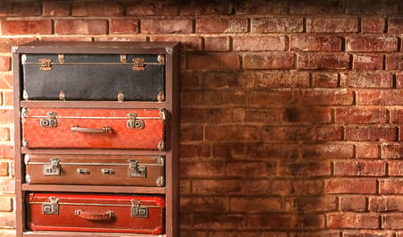 Blurred four vintage suitcases stand on top of each other against a brick wall background. High quality photoの写真素材