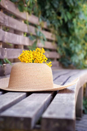 Summer composition with wicker hat, momoza on wooden background, vertical. High quality photoの写真素材