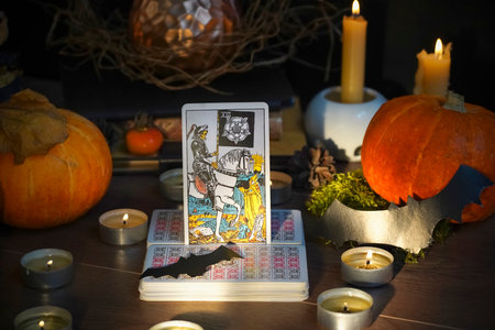 Defocused mystic ritual with tarot cards, and candles. Halloween concept, black magic or fortune telling rite with occult and esoteric symbols.のeditorial素材