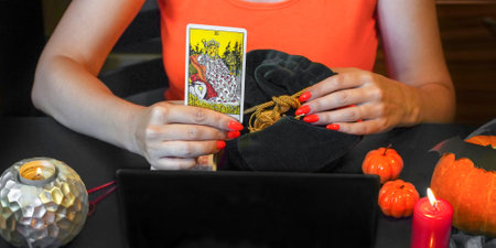 Tarot reader with tarot cards. Halloween concept, black magic or fortune telling rite with occult and esoteric symbols.のeditorial素材