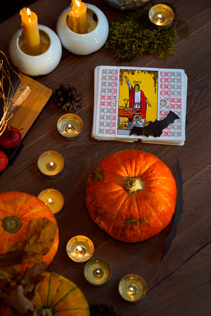 Defocused mystic ritual with tarot cards, and candles. Halloween concept, black magic or fortune telling rite with occult and esoteric symbols.のeditorial素材