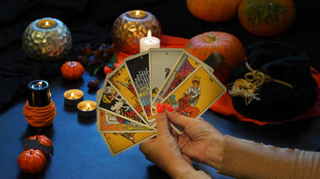 Tarot reader with tarot cards. Halloween concept, black magic or fortune telling rite with occult...