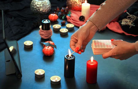 Blurred hand with matchstick, lighting a Candle. Halloween decoration. High quality photo