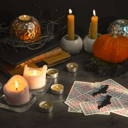 Defocused mystic ritual with tarot cards, and candles. Halloween concept, black magic or fortune telling rite with occult and esoteric symbols.のeditorial素材