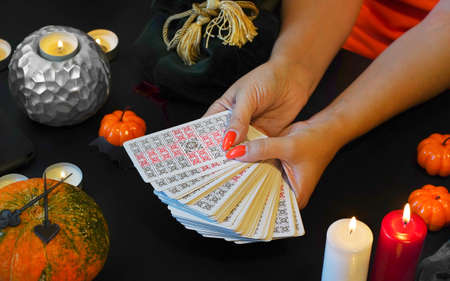 Tarot reader with tarot cards. Halloween concept, black magic or fortune telling rite with occult...