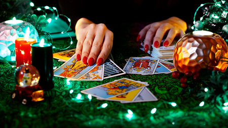 Tarot cards on table near burning candles. Tarot reader or Fortune teller reading on Christmas decoration. ... High quality photoのeditorial素材