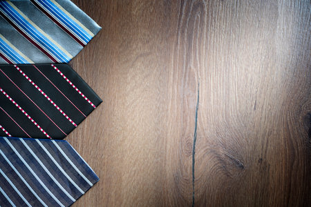 Multi-colored neckties on a brown wooden background with copy spaceの写真素材