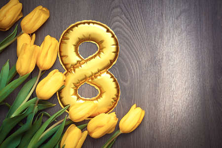 8 March, International Women's Day. Figure eight of with beautiful yellow and red tulips on wooden background. ... High quality photoの写真素材