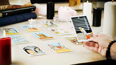 Defocused mystic ritual with tarot cards, and candles. Halloween concept, black magic or fortune...