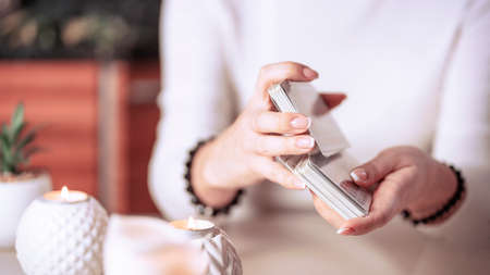 Selective Focus of two hands shuffling and adjusting tarot cardsの写真素材