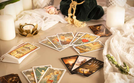 Defocused mystic ritual with tarot cards, and candles. Halloween concept, black magic or fortune telling rite with occult and esoteric symbols.のeditorial素材