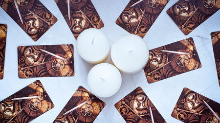 Tarot cards and White candles on the table. Fortune telling concept with occult and esoteric symbols. High quality photoのeditorial素材