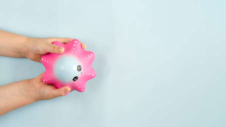 Flat lay antistress toy squish pink star in hands on Blue background. Compressing, soft, squeezable items to relieve stress, problems, anxieties, worries. Summer concept. High quality photoの写真素材