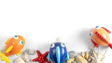 Summer game Beach concept. Seashells, fish toy on light background. View from above. Copy space. High quality photoの写真素材